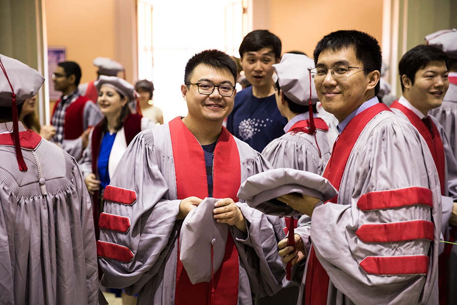 "Smiling M I T students in P H D regalia"
